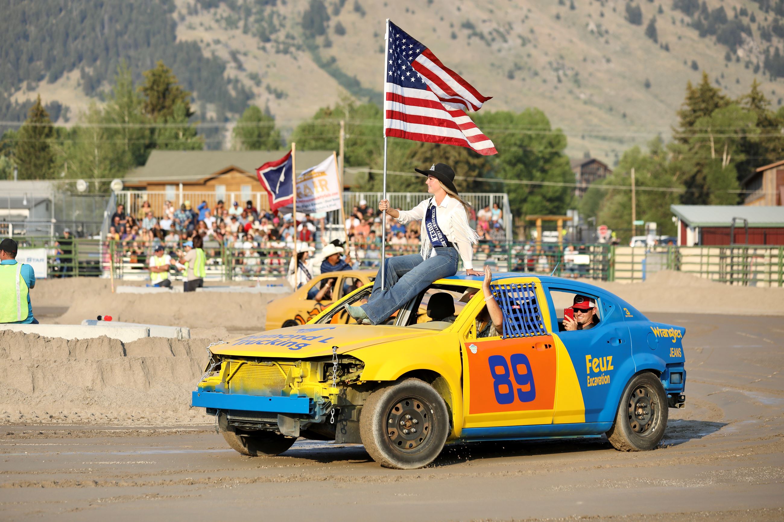 Rodeo Queen Holding the American Flag Rides on a Derby Car