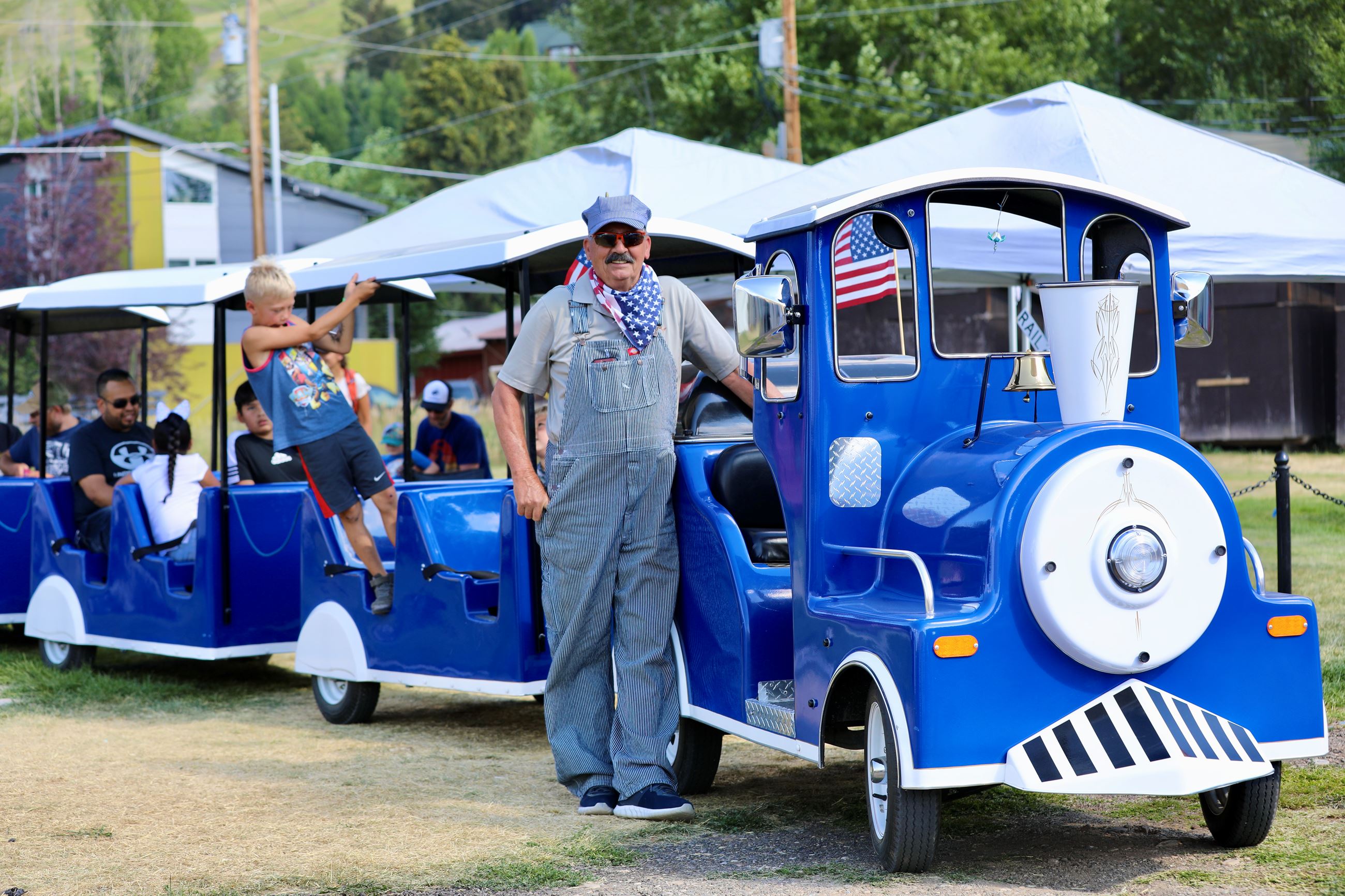 Small Train Ride Conductor Standing Next to His Train